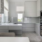 Interior of contemporary new prestige kitchen with modern equipment and white furniture in daylight